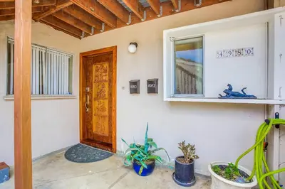 a room with a door and a window and plants at Rooftop patio ocean views surf break steps away in San Diego