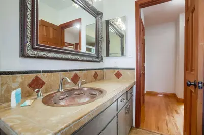 a bathroom with a sink and a mirror at Rooftop patio ocean views surf break steps away in San Diego