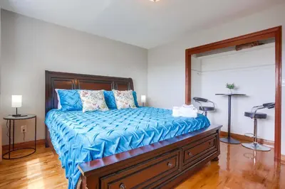 a bedroom with a bed with a blue comforter at Rooftop patio ocean views surf break steps away in San Diego