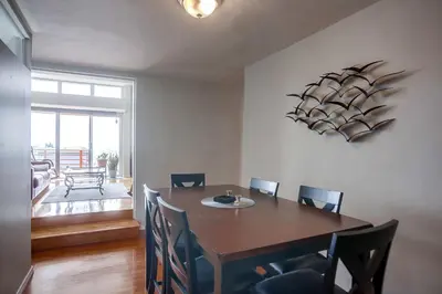 a dining room with a wooden table and chairs at Rooftop patio ocean views surf break steps away in San Diego