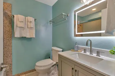 a bathroom with a toilet and a sink and a mirror at Tropical Bliss - 5BR Pool Spa Games 12 min to dwtn in San Diego