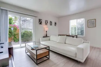 a living room with a white couch and a glass table at ocean views 3 blocks to beach AC downstairs in San Diego