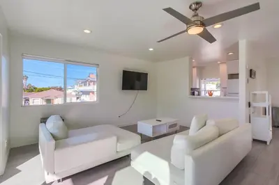 a living room with white furniture and a ceiling fan at ocean views 3 blocks to beach AC downstairs in San Diego