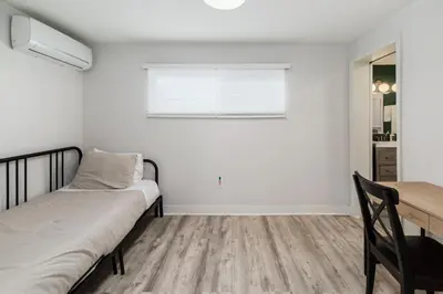 a bedroom with a bed and a table and a window at Downtown La Mesa gem in La Mesa