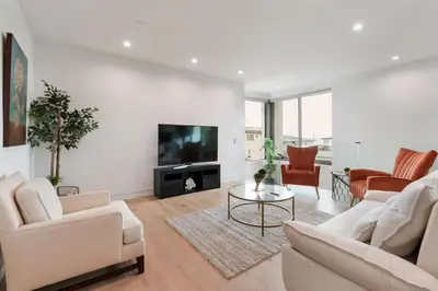 a living room with white furniture and a flat screen tv at Ocean View Luxury Living in Carlsbad