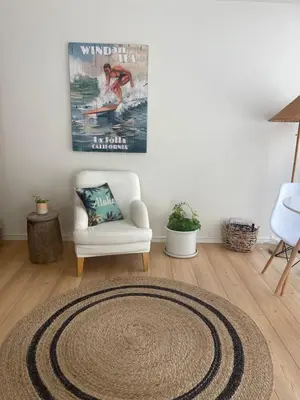a living room with a white chair and a rug at La Jolla Suite with Ocean View Patio in San Diego