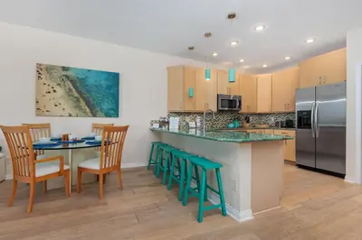 a kitchen with a counter and a table and chairs at Coastal Heights - DMBC857C in Solana Beach