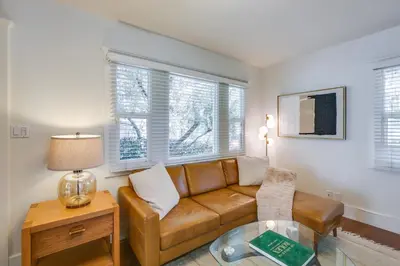 a living room with a couch and a table at Walkable Cottage Near Balboa Park with Yard and Grill! in San Diego