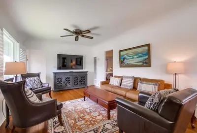 a living room with leather furniture and a ceiling fan at Spring break 2 blocks to beach pier Newport Ave in San Diego