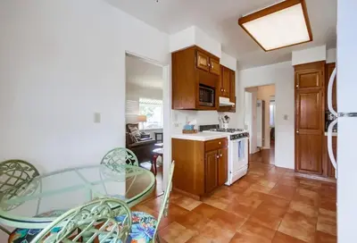 a kitchen with wooden cabinets and a table and chairs at Spring break 2 blocks to beach pier Newport Ave in San Diego