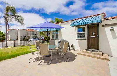 a patio with a table with chairs and an umbrella at Spring break 2 blocks to beach pier Newport Ave in San Diego