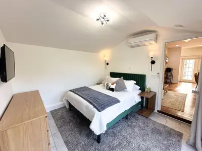 a bedroom with a bed and a flat screen tv at Oceanside Rooftop Retreat Sleeps 4 in Oceanside