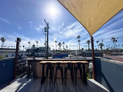 a table on a balcony with a view of a city at Oceanside Rooftop Retreat Sleeps 4 in Oceanside