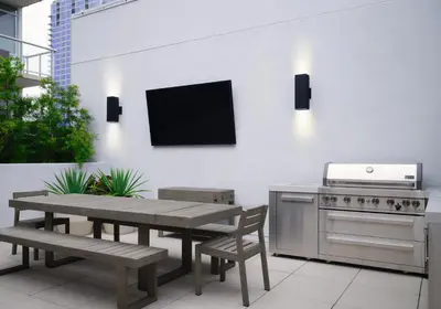 a patio with a table and a television on a wall at Sentral Gaslamp Quarter in San Diego