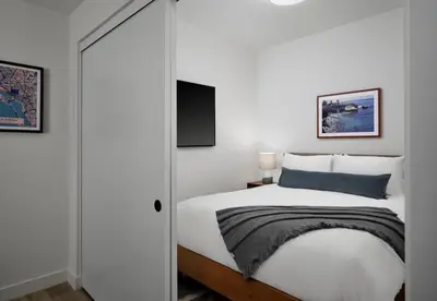 a bedroom with a white bed and a tv at Sentral Gaslamp Quarter in San Diego