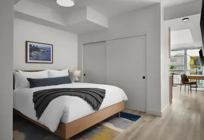 a bedroom with a large bed and a dining room at Sentral Gaslamp Quarter in San Diego