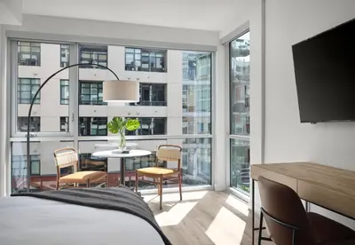 a bedroom with a table and chairs and a large window at Sentral Gaslamp Quarter in San Diego