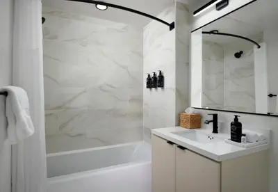 a white bathroom with a tub and a sink at Sentral Gaslamp Quarter in San Diego