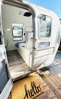 an open door of a white van with a mat at Stay in Style - Airstream & Views in Spring Valley