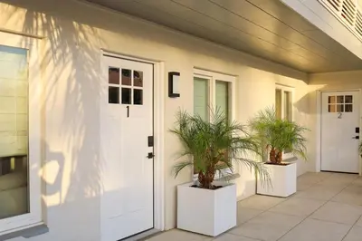 a house with two potted plants on a porch at Chic Surf Lodge with Hot Tub & Ocean Views in Oceanside