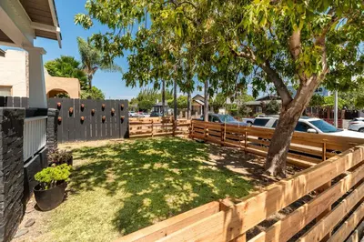 a wooden fence with a tree in a yard at Modern Gem in North Park in San Diego