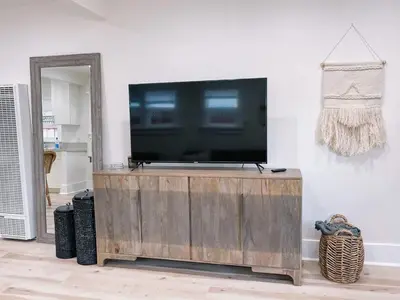 a flat screen tv sitting on top of a wooden entertainment center at Modern Gem in North Park in San Diego