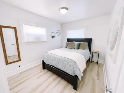 a white bedroom with a bed and a mirror at Modern Gem in North Park in San Diego