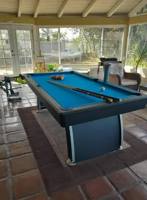 a pool table with two cuesticks on a patio at Big Beautiful Master Bedroom in Bonita