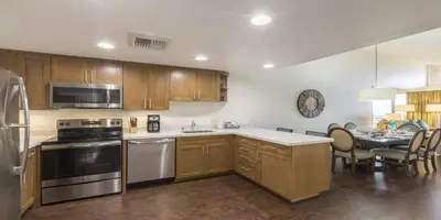 a kitchen with stainless steel appliances and a table with chairs at Grand Pacific Palisades in Carlsbad
