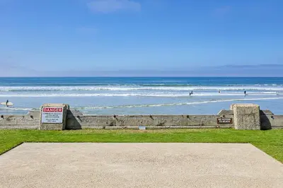a view of the beach with people in the water at Oceanside Beach Condos in Oceanside