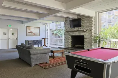 a living room with a pool table in front of a fireplace at Oceanside Beach Condos in Oceanside