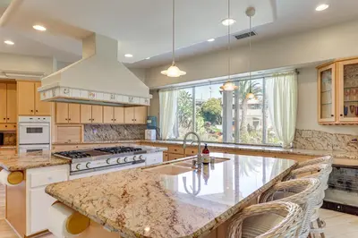 a large kitchen with a counter top and a large window at 3 Mi to Beach Central and Elegant Home in Oceanside in Oceanside