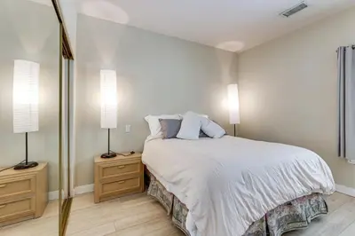 a bedroom with a bed with two lamps and a mirror at 3 Mi to Beach Central and Elegant Home in Oceanside in Oceanside