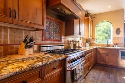 a kitchen with wooden cabinets and a stove top oven at Pool Hot Tubs Views - Castillo de Windsor in San Diego