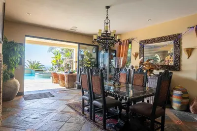 a dining room with a table and chairs and a mirror at Pool Hot Tubs Views - Castillo de Windsor in San Diego