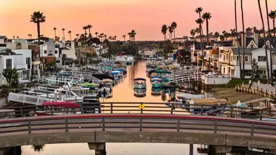 a marina with boats in the water and palm trees at Bayside Getaway Waterfront in Newport Beach