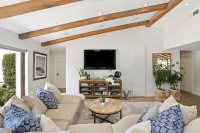 a living room with a couch and a tv at Private Wading Pool Home with Patio in Corona del Mar