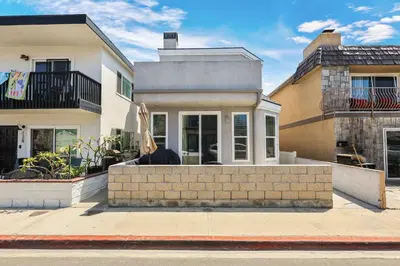 a house with a brick wall in front of it at Newport Retreat A - Fab for 4 in Newport Beach