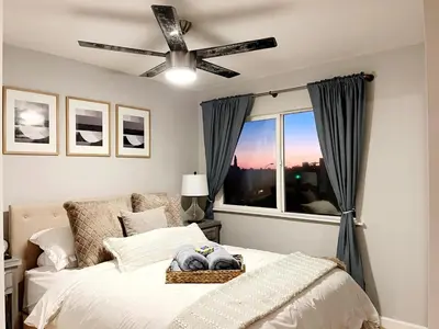 a bedroom with a bed with a ceiling fan and a window at Bright & Quiet 1-Bed Condo with Balcony in San Diego