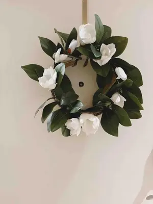 a wreath of white flowers is hanging on a wall at Bright & Quiet 1-Bed Condo with Balcony in San Diego
