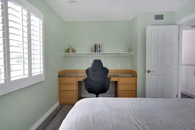 a bedroom with a black chair sitting at a desk at Serene hillside oasis with pool - 20 min to beach in Oceanside