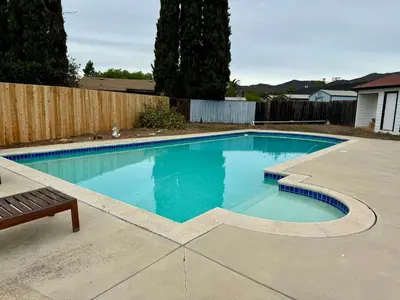 a swimming pool in a backyard with a wooden fence at Bella Vista Spacious 5-bed home with stunning mountain views and pool in Vista