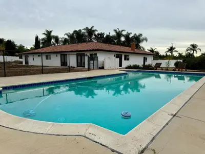 a large blue swimming pool in front of a house at Bella Vista Spacious 5-bed home with stunning mountain views and pool in Vista