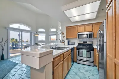 a kitchen with a sink and a stove at Nomad's Oceanfront Retreat 2B2B Condo in Oceanside