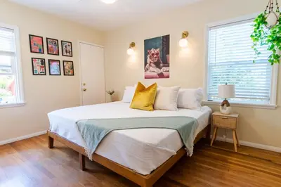 a bedroom with a bed with white sheets and yellow pillows at Ultimate Escape! Huge Yard Parking Walk to Beach in San Diego