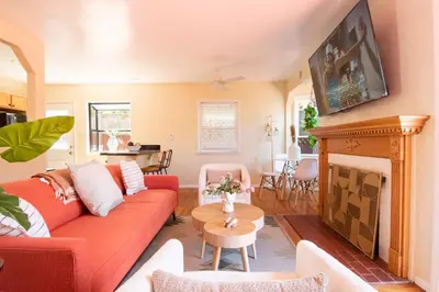 a living room with a red couch and a fireplace at Ultimate Escape! Huge Yard Parking Walk to Beach in San Diego