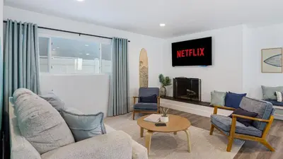 a living room with a couch and chairs and a tv at Coastal-Chic Newport Stay Steps to the Beach Dining Boardwalk Optional Add-On Unit in Newport Beach