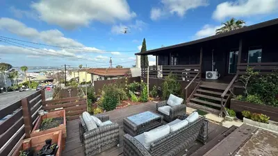 a balcony with chairs and an airplane flying over a house at Suite Steps to San Diego Top Spots in San Diego