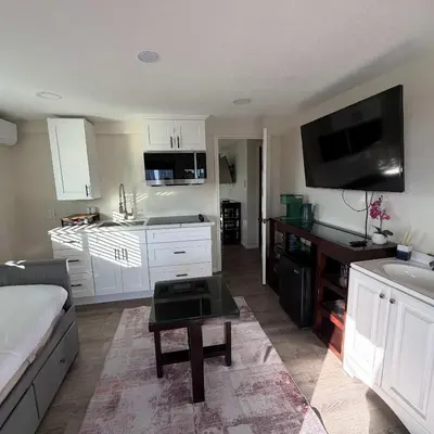 a living room with a couch and a kitchen at Suite Steps to San Diego Top Spots in San Diego