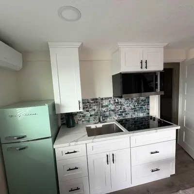 a kitchen with white cabinets and a green refrigerator at Suite Steps to San Diego Top Spots in San Diego
